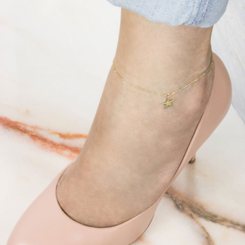 Dainty Yellow Gold Anklet with a Dangling Starfish Charm Worn By A Woman