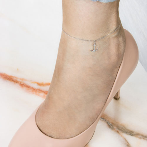 Small White Gold Anchor Charm Anklet Worn By A Woman