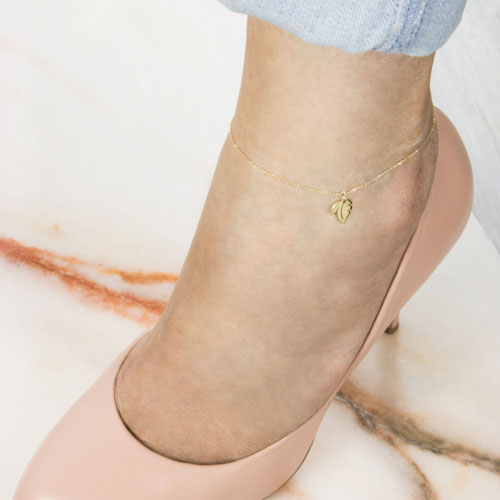 Elegant Yellow Gold Anklet with a Double Leaf Charm Worn By A Woman