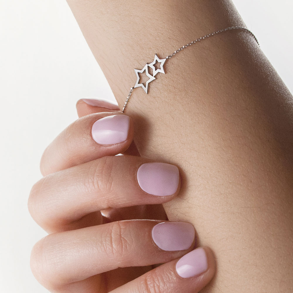 Double Star Charm Bracelet in White Gold Worn By A Woman