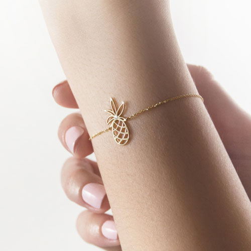 Yellow Gold Pineapple Charm Bracelet with a Tiny White Diamond Worn By A Woman