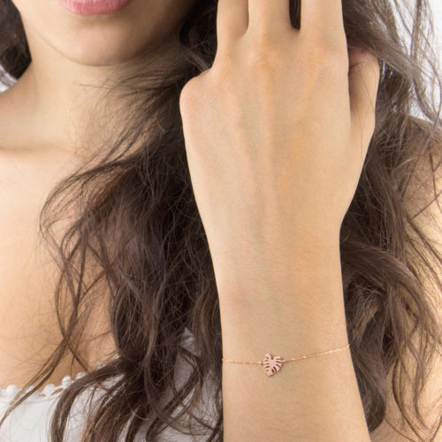 Rose Gold Charm Bracelet with a Tropical Monstera Leaf Worn By A Woman