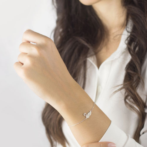 Dainty Bracelet with a Beautiful White Gold Swan Worn By A Woman