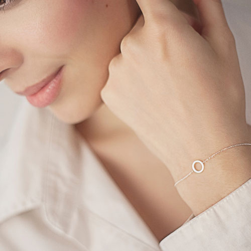 Simple Yellow Gold Bracelet with a Small Circle Worn By A Woman