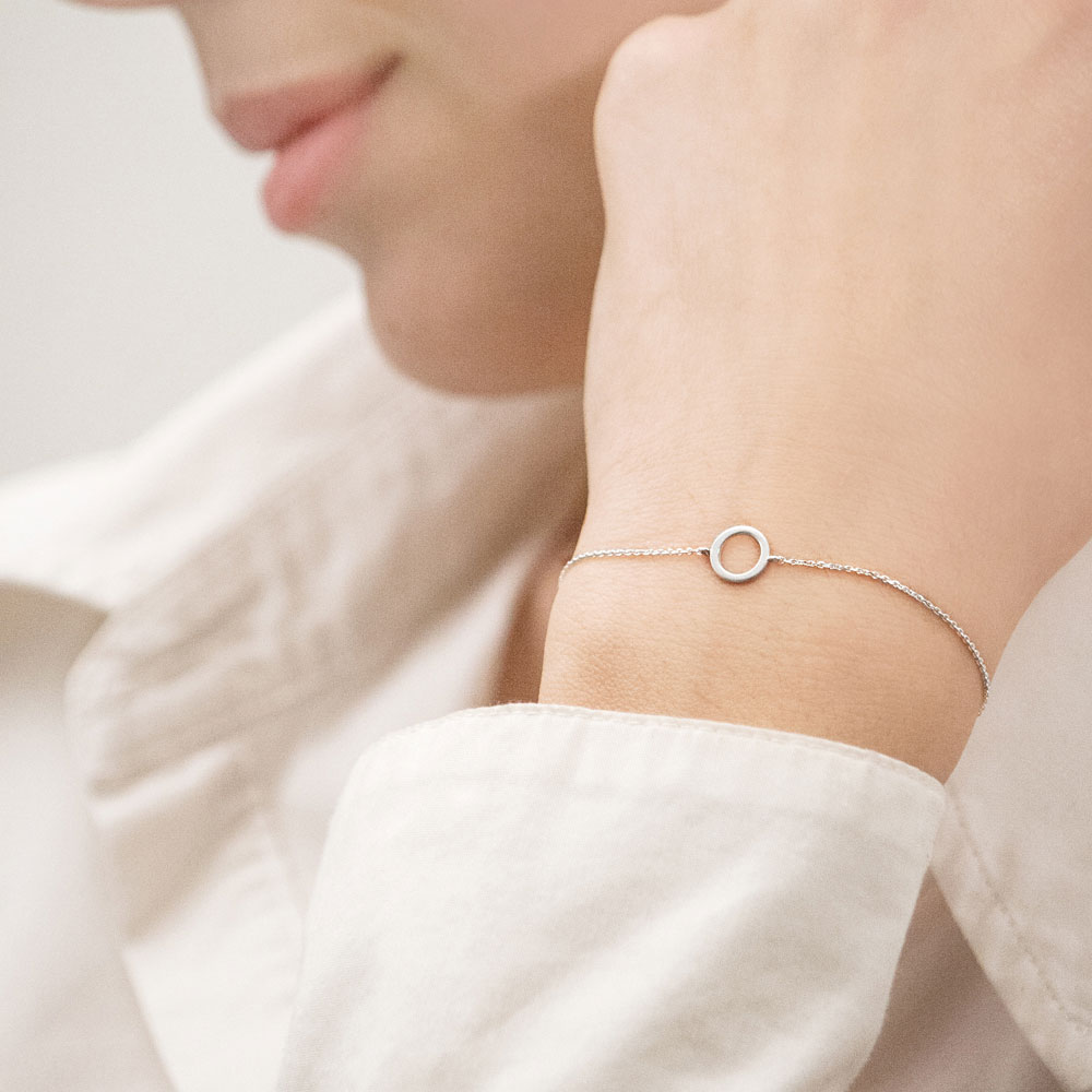 Simple White Gold Bracelet with a Small Circle Worn By A Woman