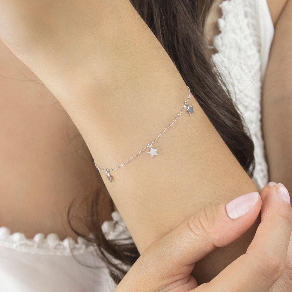Dainty Bracelet with Tiny White Gold Stars Dangling Worn By A Woman