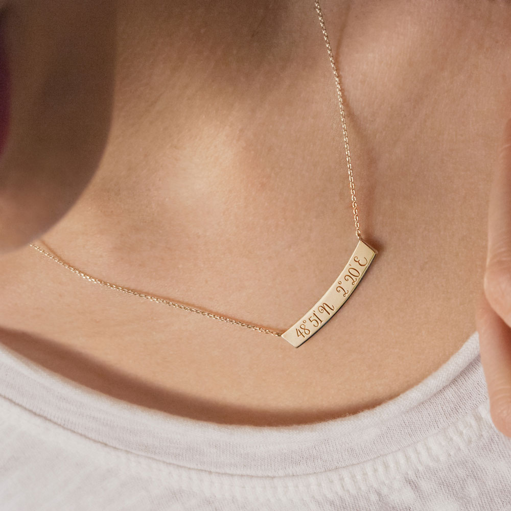 Yellow Gold Bar Necklace with Engraved Coordinates Worn By A Woman
