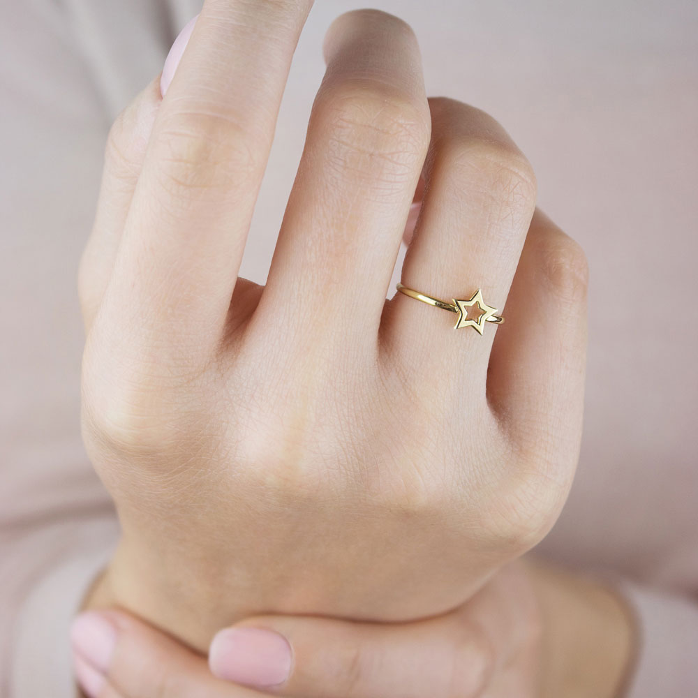 Yellow Gold Ring with a Small Star Worn By A Woman