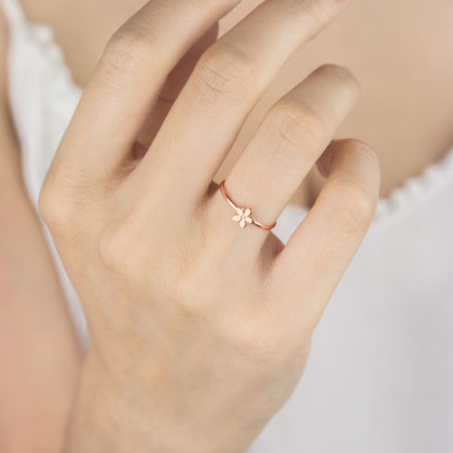 Tiny Flower Ring made of Rose Gold Worn By A Woman
