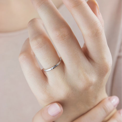 Thin Wedding Band with a Hammered Finish in White Solid Gold Worn By A Woman