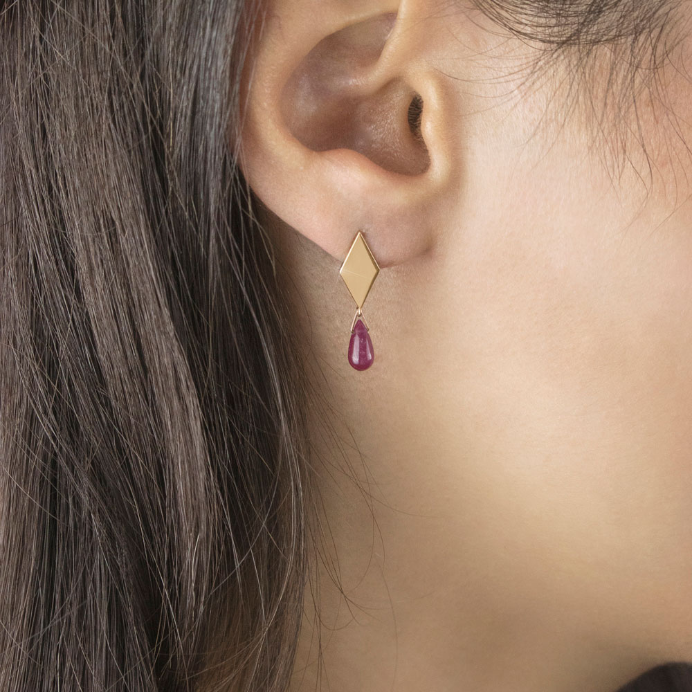 Tiny Dangling Ruby In Yellow Gold Rhombus Stud Earrings Worn By A Woman
