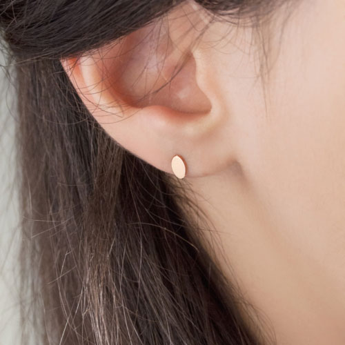 Tiny Oval Stud Earrings made of Rose Gold Worn By A Woman