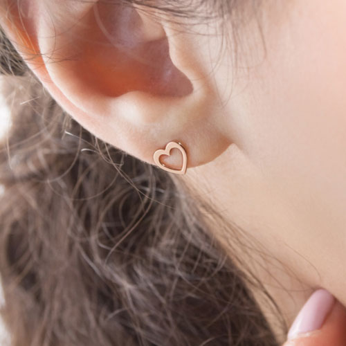 Rose Gold Tiny Heart Stud Earrings Worn By A Woman
