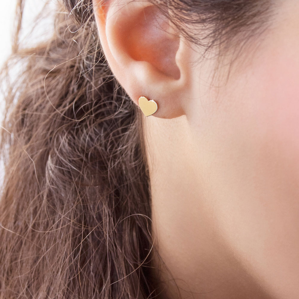 Solid Heart Yellow Gold Stud Earrings Worn By A Woman