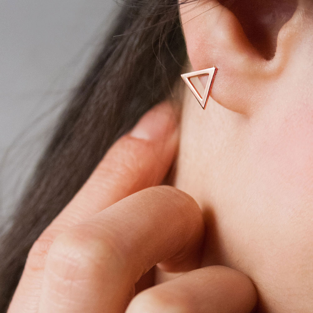 Dainty Triangle Stud Earrings made of Rose Gold Worn By A Woman