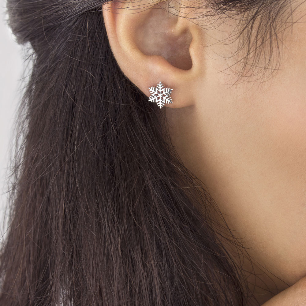 Dainty Snowflake Stud Earrings made of White Gold Worn By A Woman