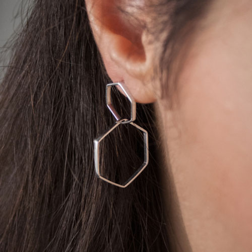 Two Dangling Hexagons Earrings in White Gold Worn By A Woman