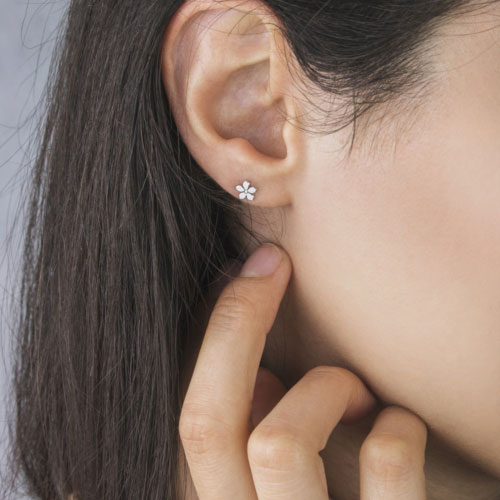 Tiny Flower Earrings in White Gold Worn By A Woman