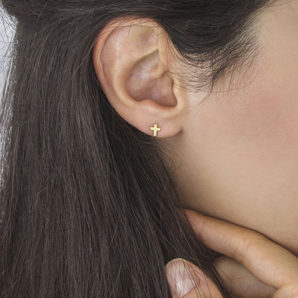 Tiny Cross Stud Earrings made of Yellow Gold Worn By A Woman
