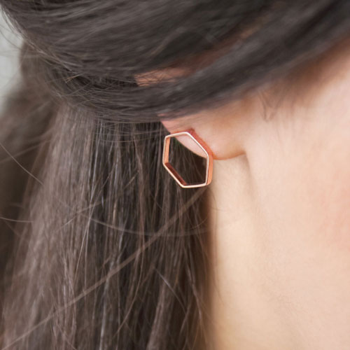 Small Hexagonal Earrings made of Rose Gold Worn By A Woman