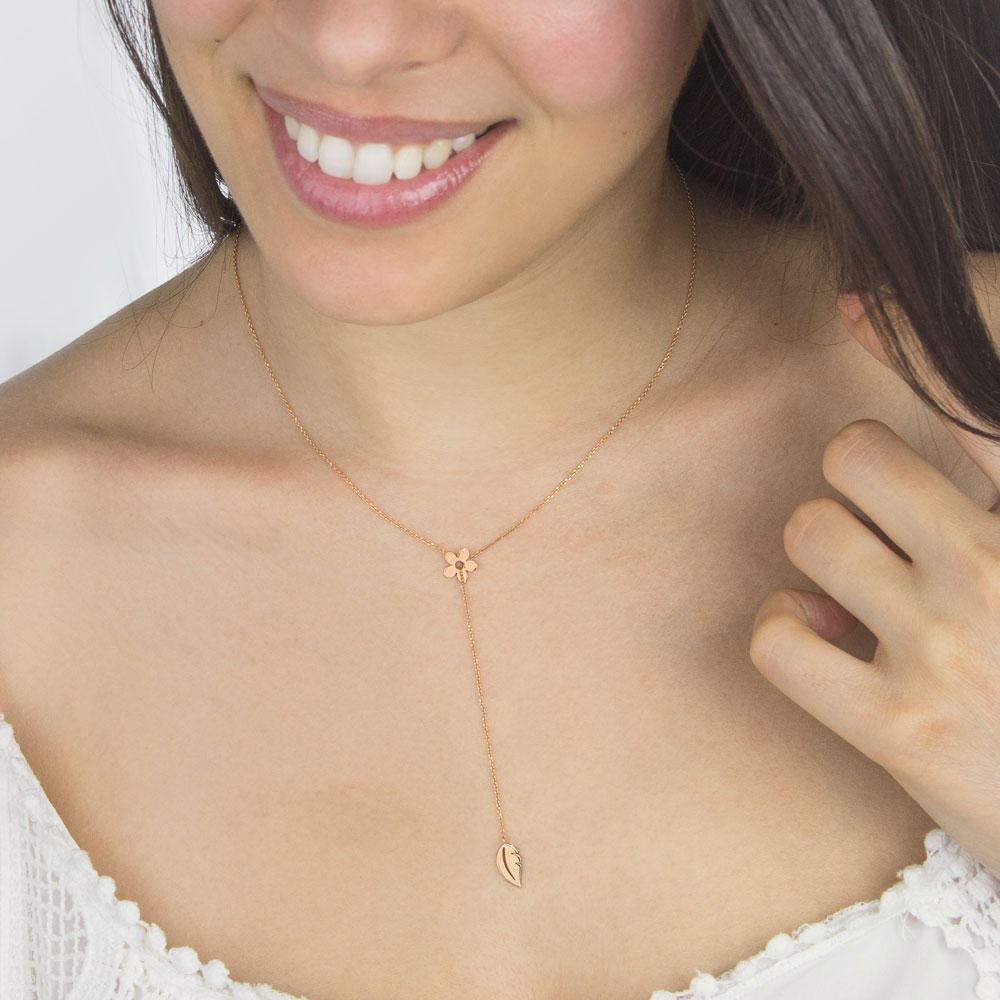 Gold Lariat Style Necklace with a Flower and a Leaf In Rose Gold Worn By A Woman