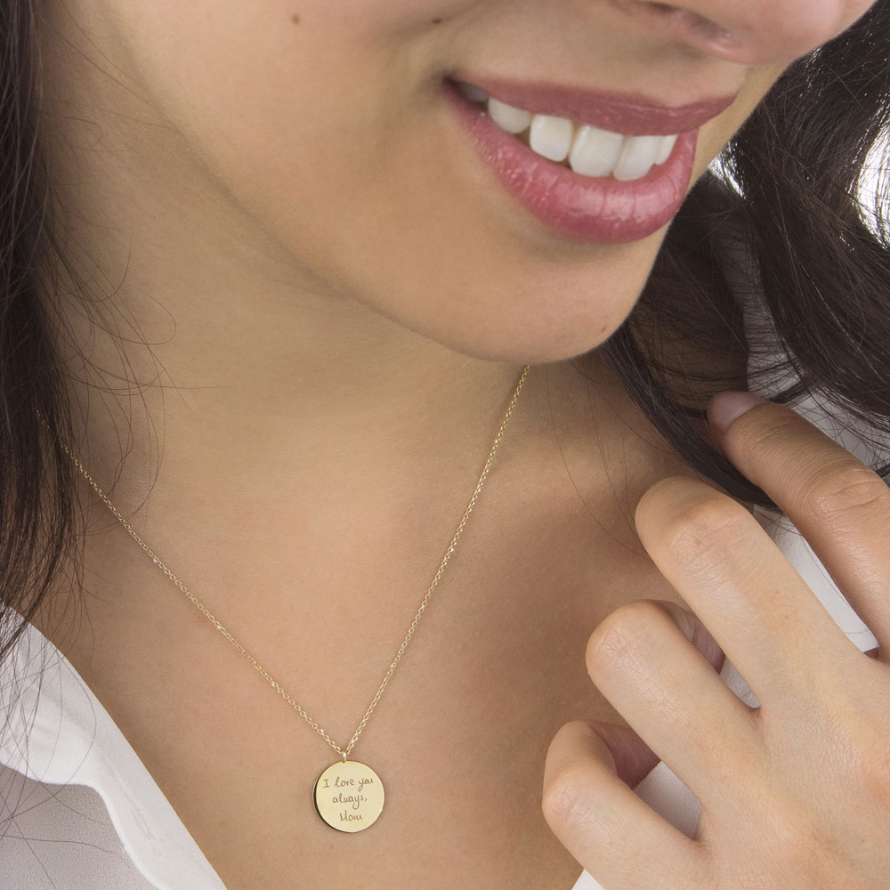 A small engraved disc necklace in yellow gold