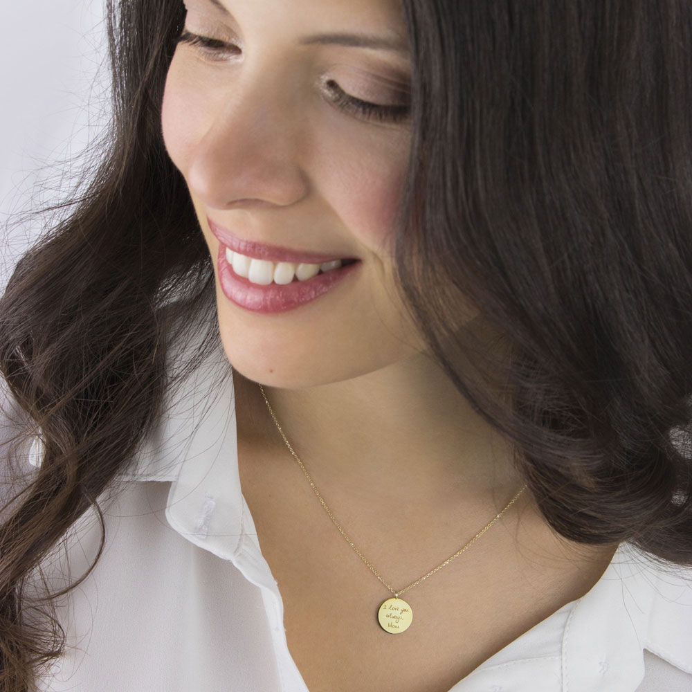 A small engraved disc necklace in yellow gold