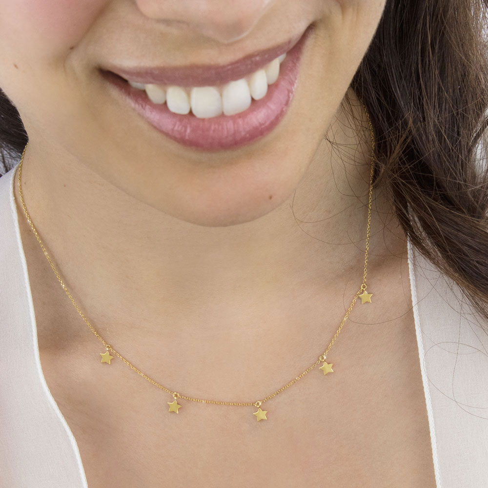 Tiny Multi Stars, Yellow Gold Dangling Necklace Worn By A Woman