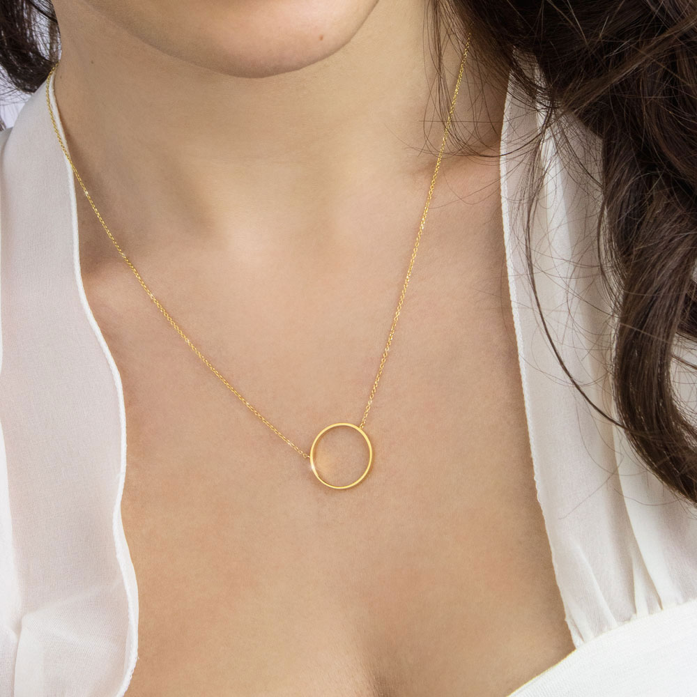 Gold Circle Charm Necklace in Yellow Gold Worn By A Woman