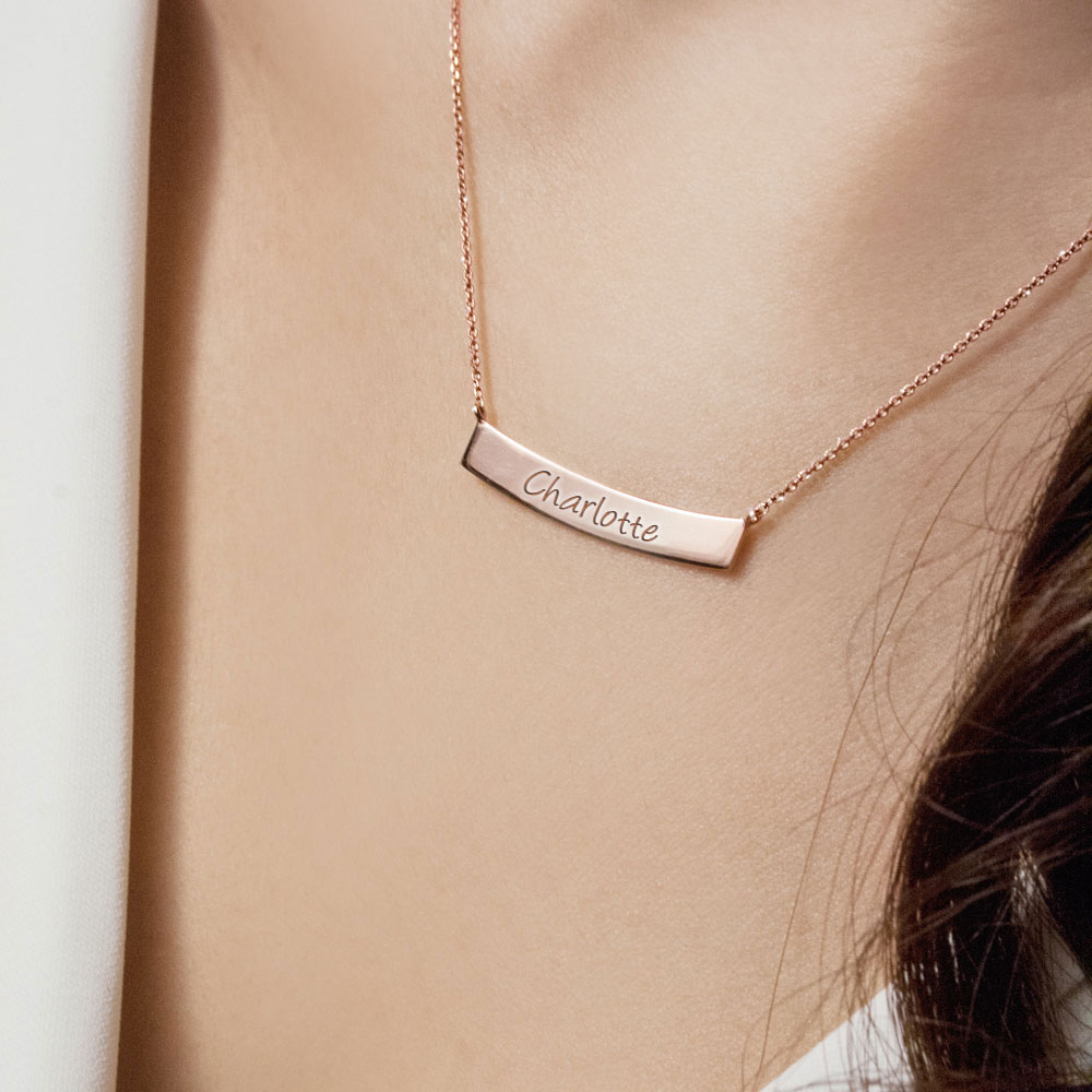 Gold Curved Bar Necklace with Custom-Engraving In Rose Gold Worn By A Woman