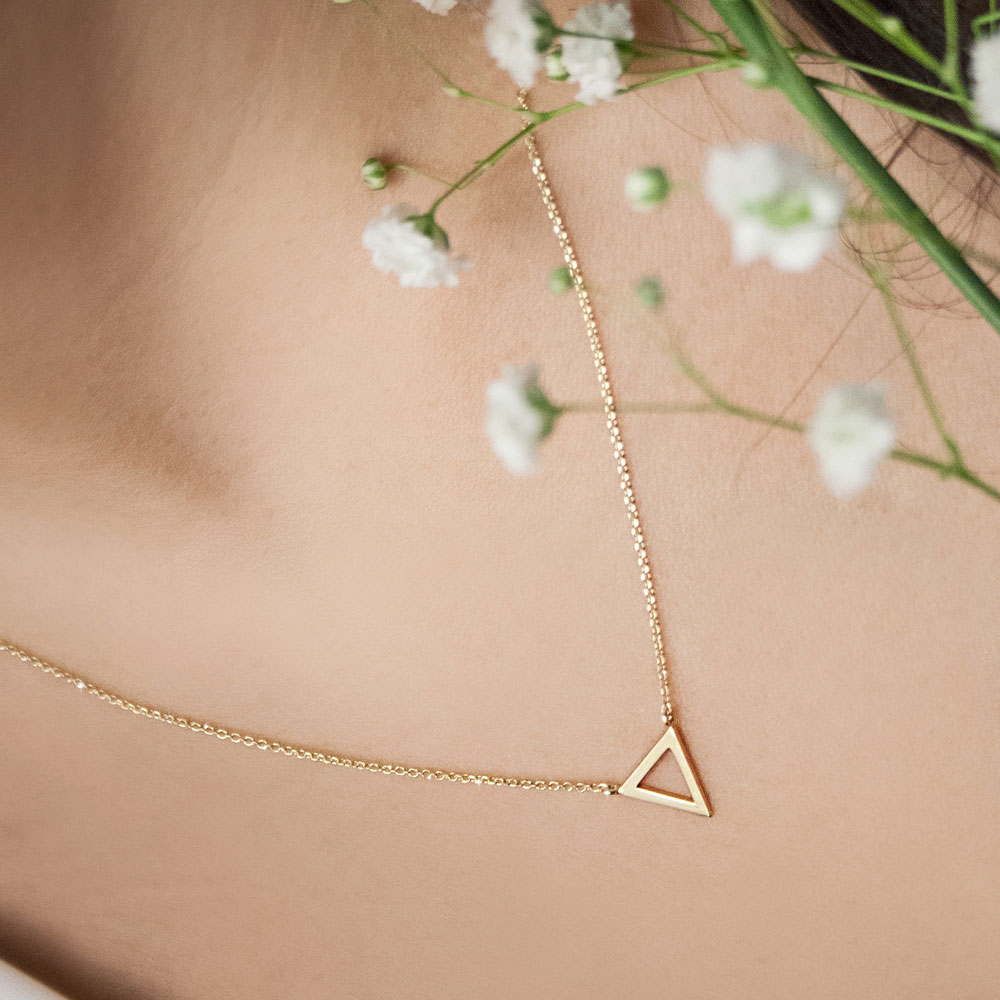 Dainty Triangle Charm Necklace in Yellow Gold Worn By A Woman