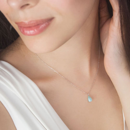 Blue Opal Birthstone Pendant Necklace with a White Gold Chain Worn By A Woman