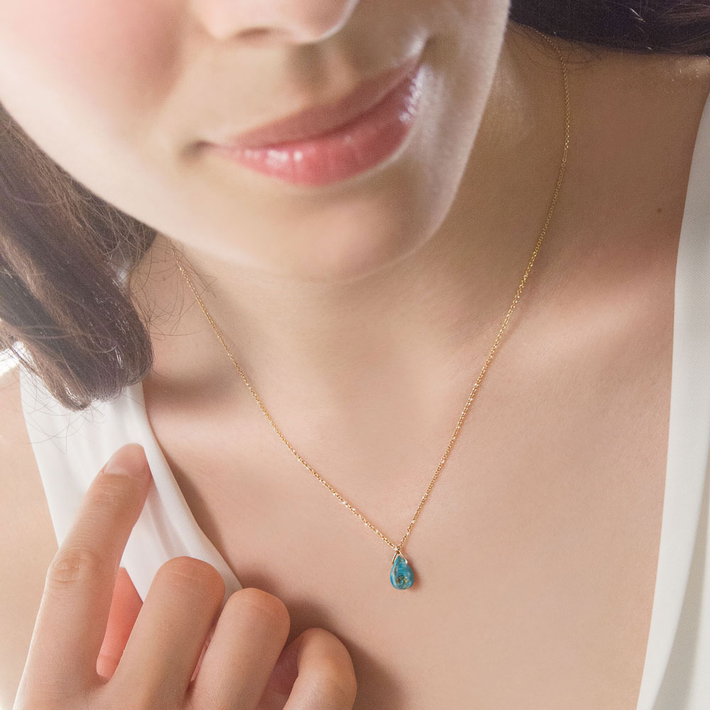 Turquoise Birthstone Pendant Necklace with a Yellow Gold Chain Worn By A Woman
