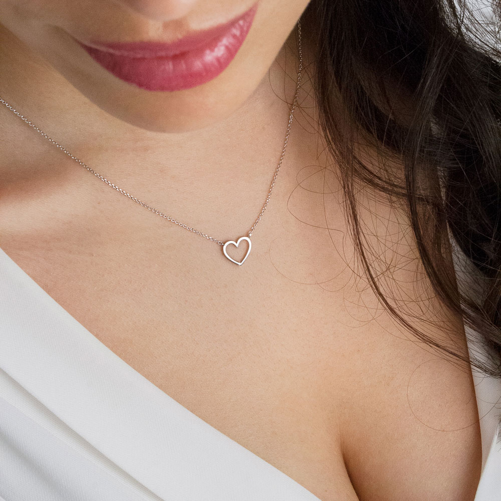 Dainty Heart Charm Necklace in White Gold Worn By A Woman