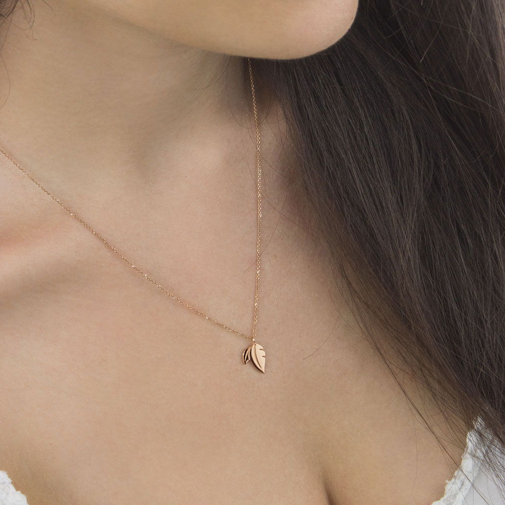 Floral Gold Pendant Necklace with a Double Leaf In Rose Gold Worn By A Woman