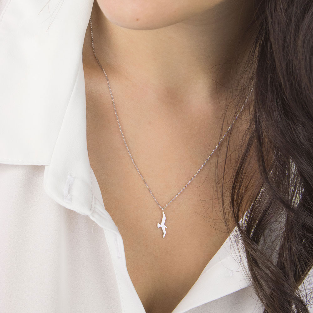 Small Bird Pendant Necklace in White Gold Worn By A Woman