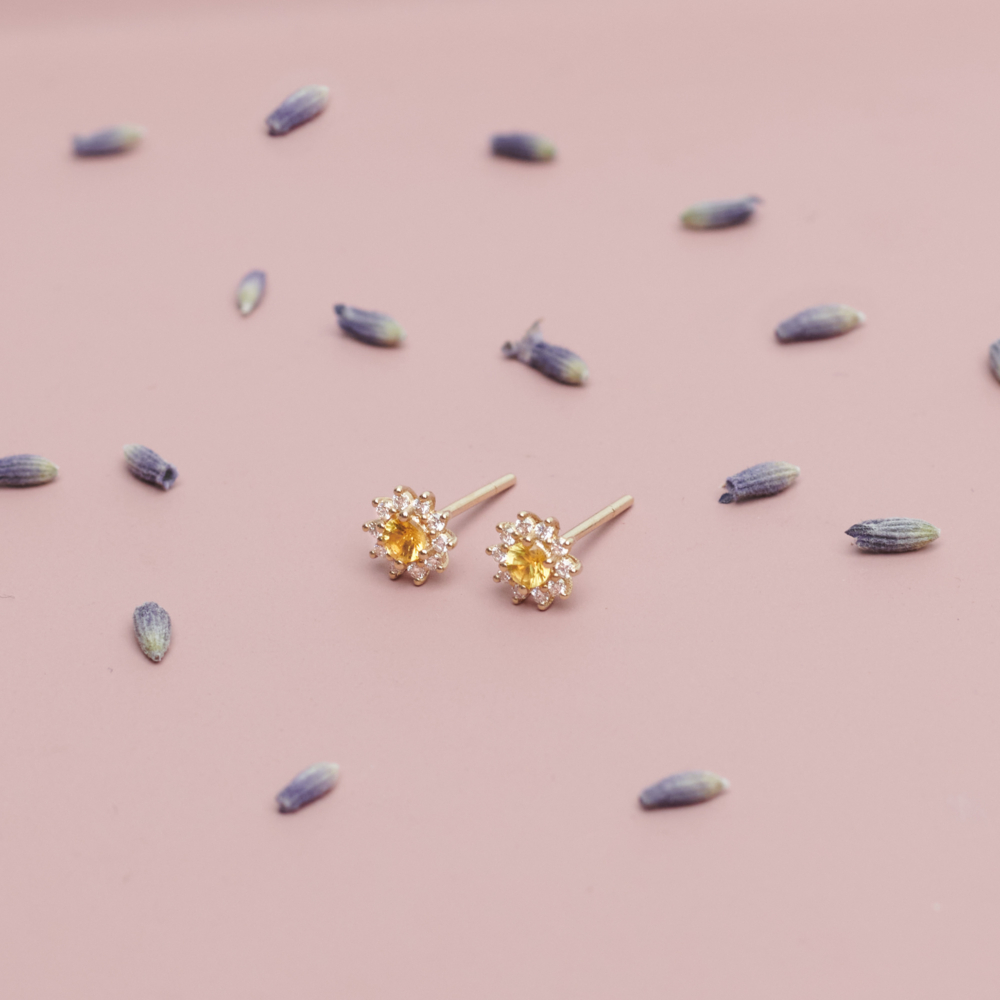 Yellow Sapphire and Diamond Earrings in Solid Gold on a pink backround with flowers