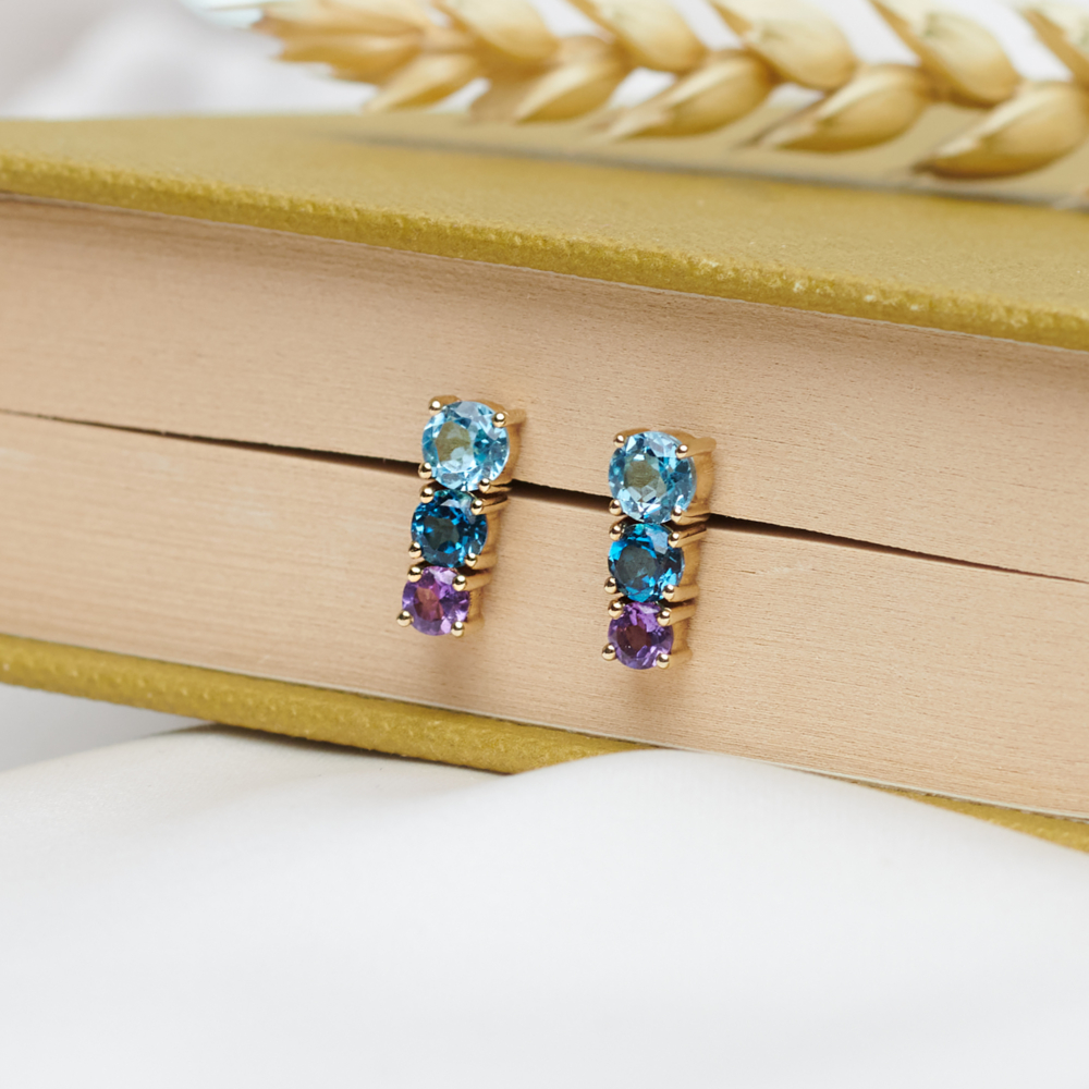 Amethyst, London and Swiss Blue Topaz Gold Earrings sitting between books pages
