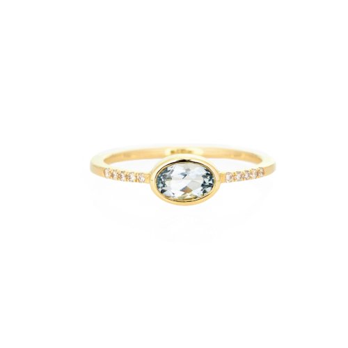 An oval sky blue topaz with tiny white diamonds yellow gold ring.