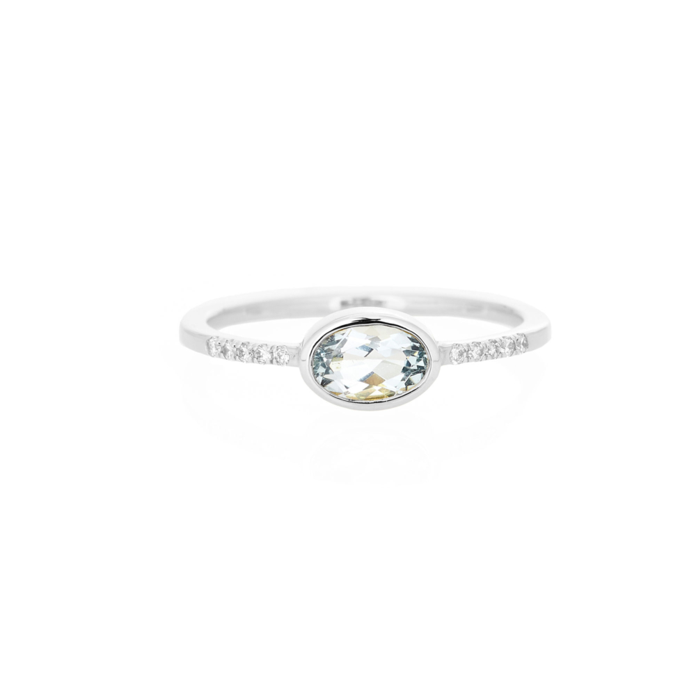 An oval sky blue topaz with tiny white diamonds white gold ring.