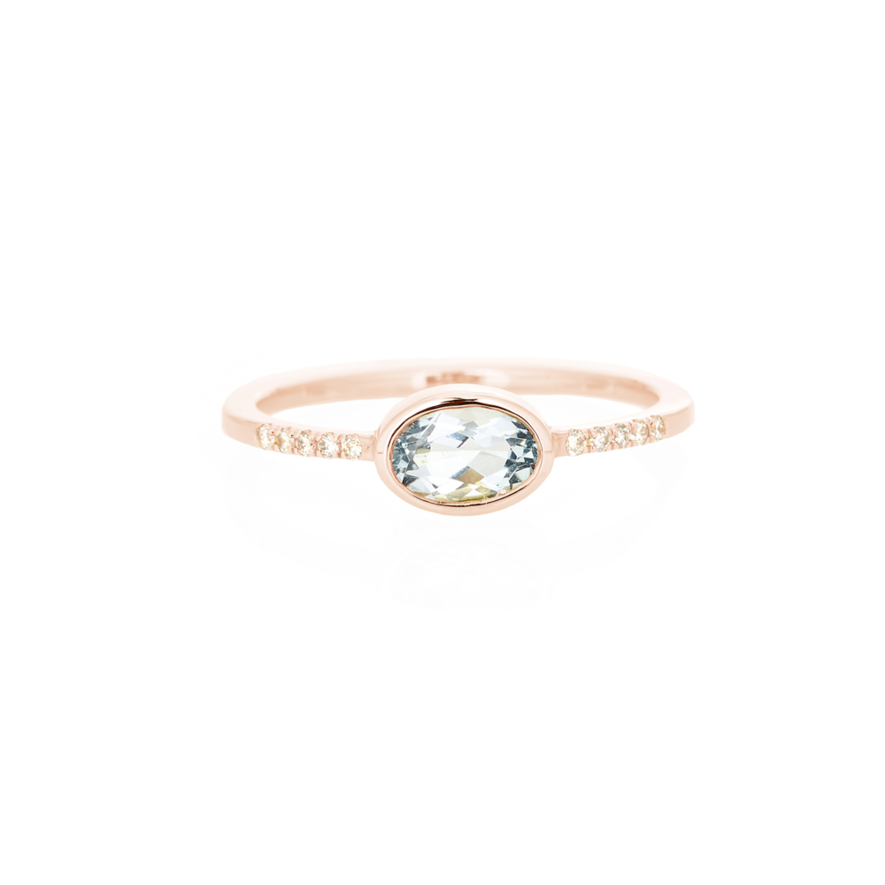 An oval sky blue topaz with tiny white diamonds rose gold ring.