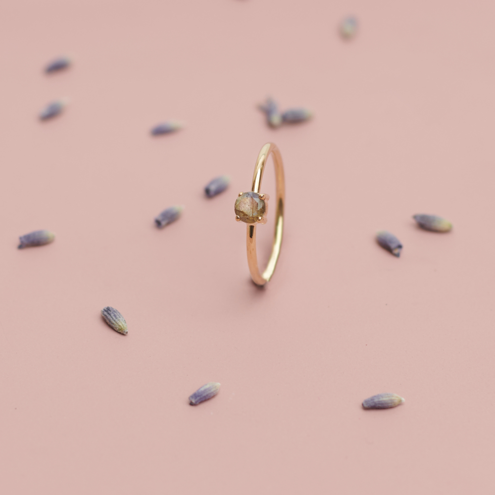 labradorite solitaire ring in solid gold on a pink background