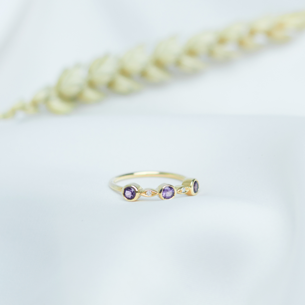 multiple gemstones ring in solid gold on a white sheet