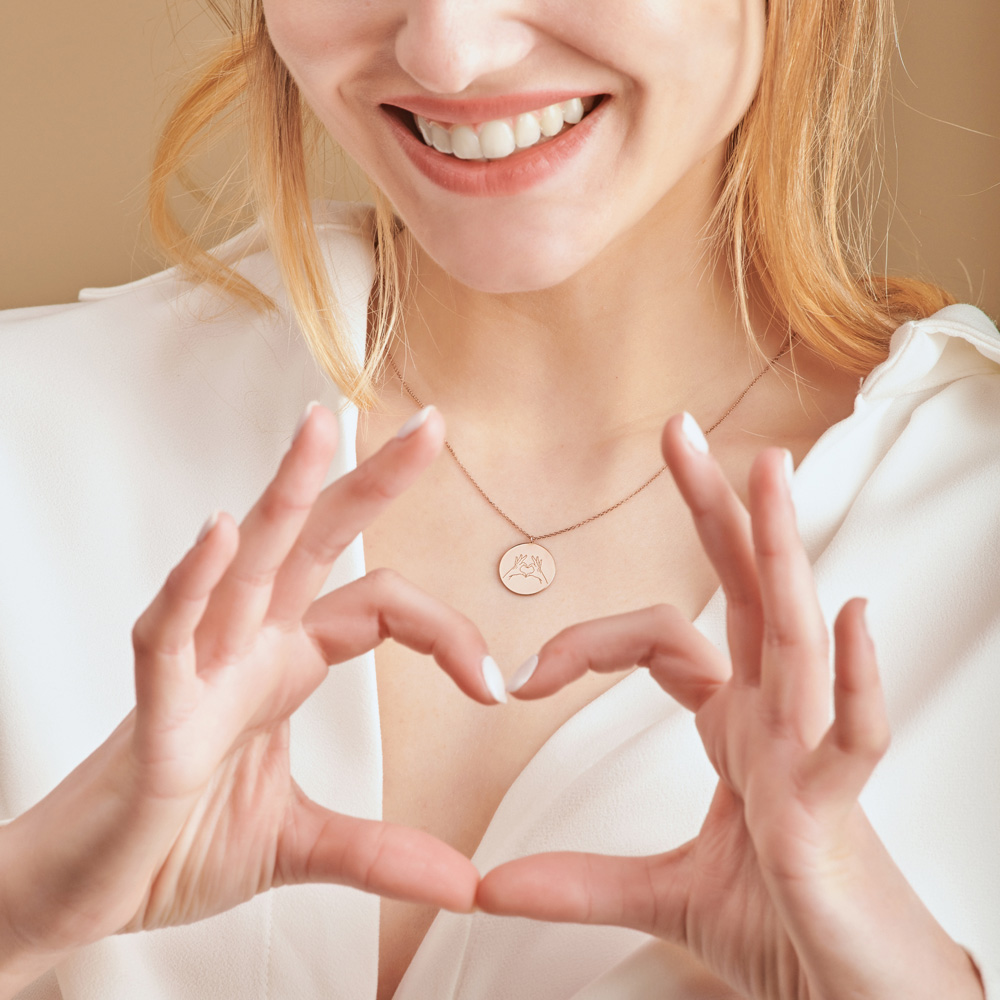 Hand Gesture Heart Pendant in rose Gold worn by a model