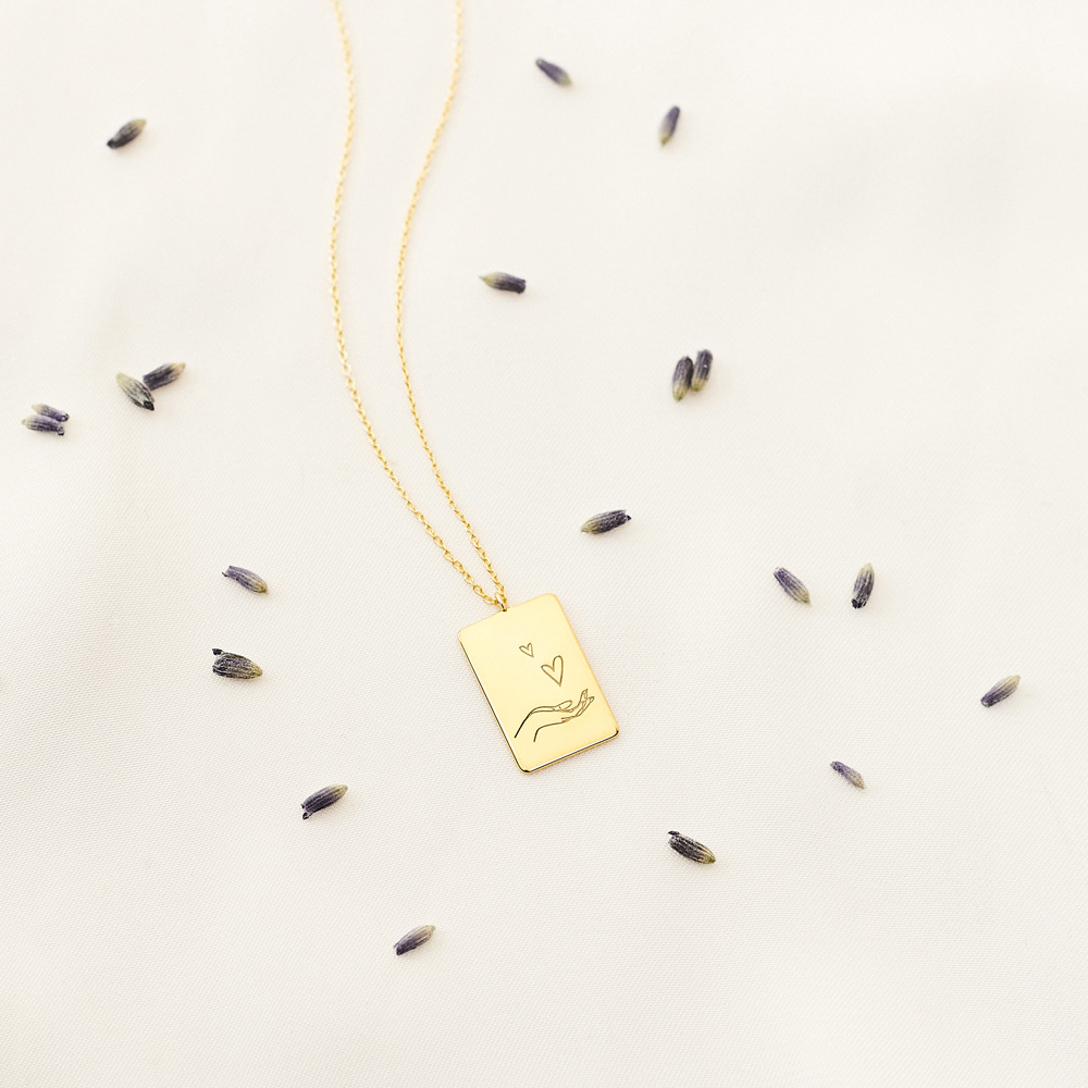 Romantic Rectangular Pendant Necklace in yellow Gold on a white background with leaves