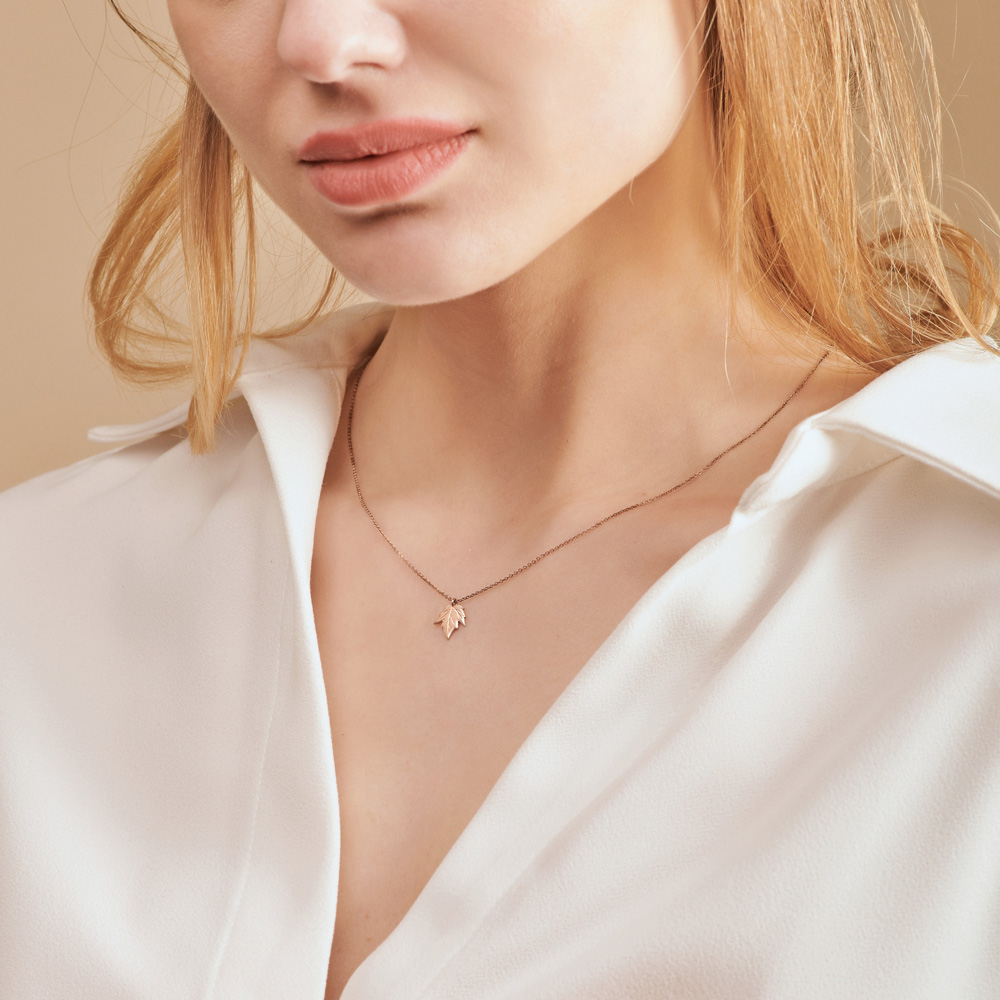 Small Maple Leaf Charm Necklace in Rose Gold worn by a model